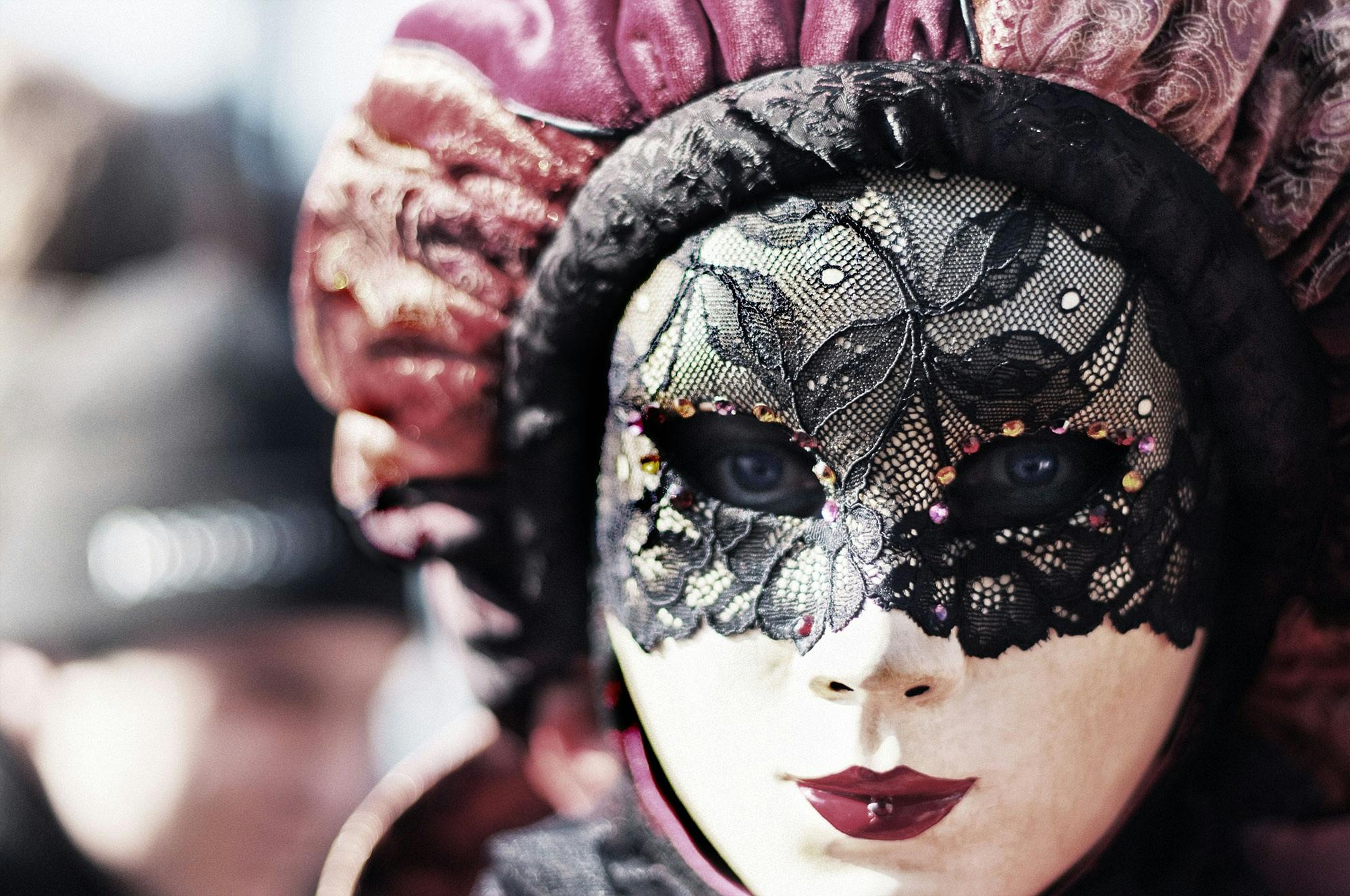 Close-up of a woman in a detailed Venetian mask, embodying mystery and elegance.