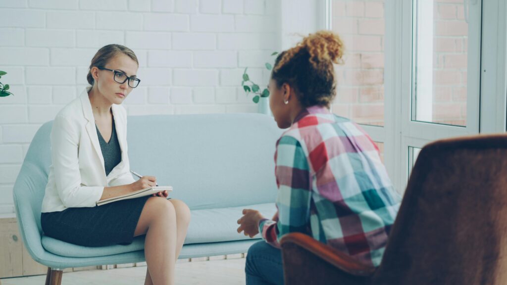 A therapist listens attentively during a private counseling session about repeating patterns in relationships